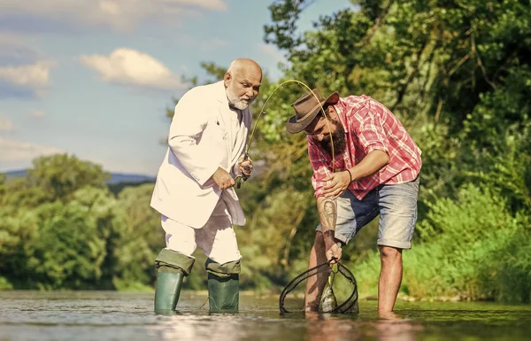 Somos uma família. Conceito de captura e pesca. pai aposentado e filho barbudo maduro. felizes pescadores amizade. Dois amigos a pescar juntos. passatempo de peixe de mosca de homem de negócios. pesca de reforma — Fotografia de Stock