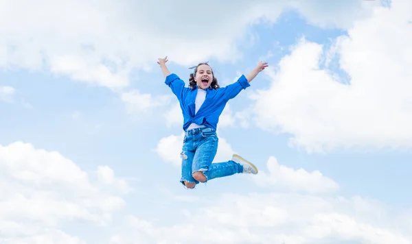 Веселый ребенок прыгать в повседневной джинсовой одежде на открытом воздухе, счастье — стоковое фото