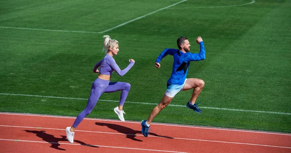 Atlético casal de velocistas correr em pista de corrida no estádio, sucesso — Fotografia de Stock