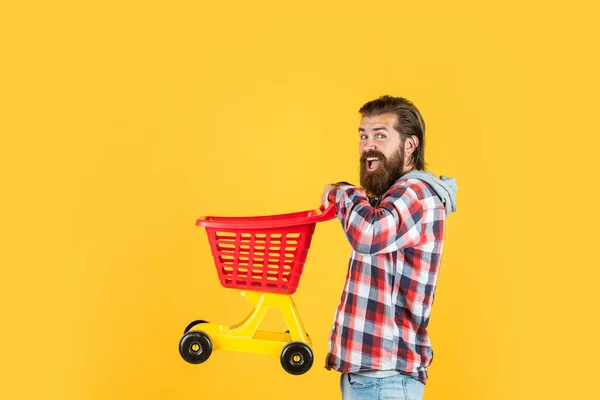 Männliche Hipster mit modisch gepflegten Haaren und Bart tragen Einkaufswagen, tägliche Routine — Stockfoto