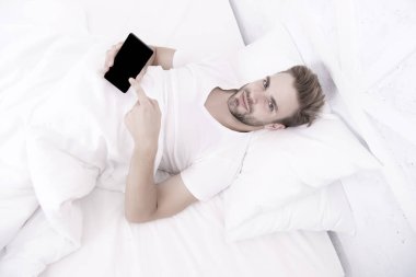 Uygulama, uyku evrelerini analiz eder ve sizi en uygun zamanda uyandırır. Uykuyu takip eden uygulamalar. Adam yatakta cep telefonu kullanıyor. Uyanıyorum. Daha derin uyku analizi yap. Sabah alarmını kur.