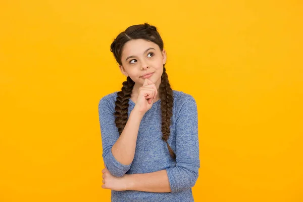 Nachdenkliches Teenager-Mädchen. hübsches Kind mit geflochtenen brünetten Haaren. Haarpflege und Styling. Schönheit und Mode. Friseursalon für Kinder. glückliche Kindheit. in Freizeitkleidung — Stockfoto