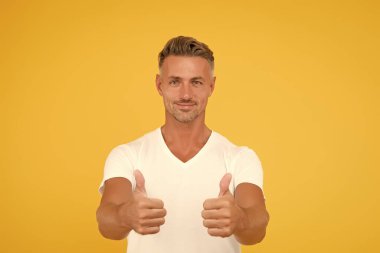 Görsel reklam. Mutlu adam başparmağını kaldırdı. Reklam ajansı sarı arka plan. Ürünü onaylamak ve reklamını yapmak. Reklamlar. Reklam kampanyası. Satış promosyonu. Pazarlama iletişimi