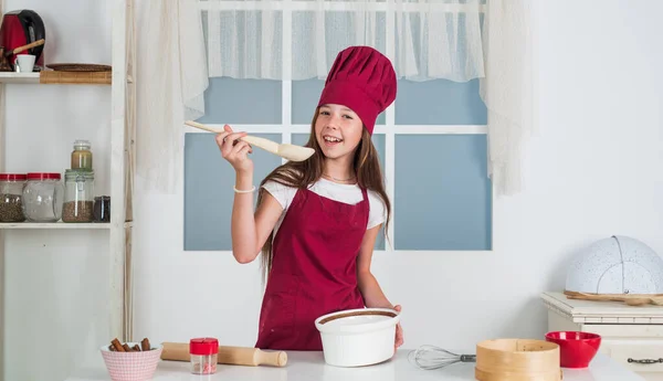 Девочка в фартуке шеф-повара и шляпе приготовления пищи, пекарня — стоковое фото
