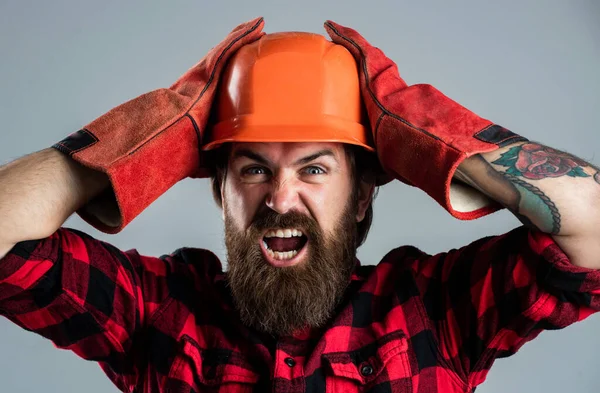 Šokovaný asistent. inženýrský koncept. opravárenská dílna. vousatý muž pracovník v helmě — Stock fotografie
