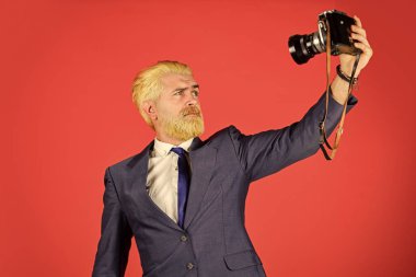 Şık ve eski moda. İçerik yaratan. Neşeli sakallı hippi fotoğrafçı. Kameralı eksantrik bir fotoğrafçı. Elle ayarlar. Sakallı bir fotoğrafçı. Klasik tarz eğilimi