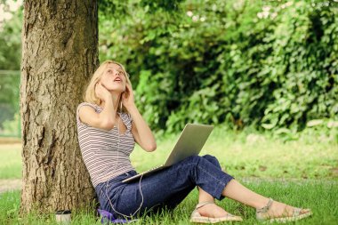 Yaz parkında çalışıyorum. Neden işini dışarıda yapman gerektiğinin sebepleri. Doğa, işyerinde refah ve üretken ve yüksek işlevli olma yeteneği için gereklidir. Park yerinde dizüstü bilgisayarla çalışan bir kız.