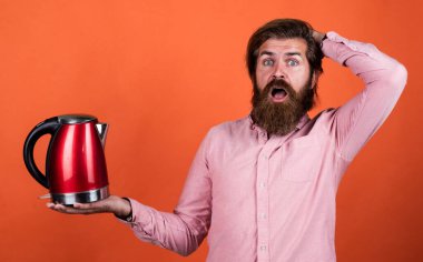 Tişörtünde sakal olan vahşi beyaz hippi elektrikli su ısıtıcısı, teknoloji.