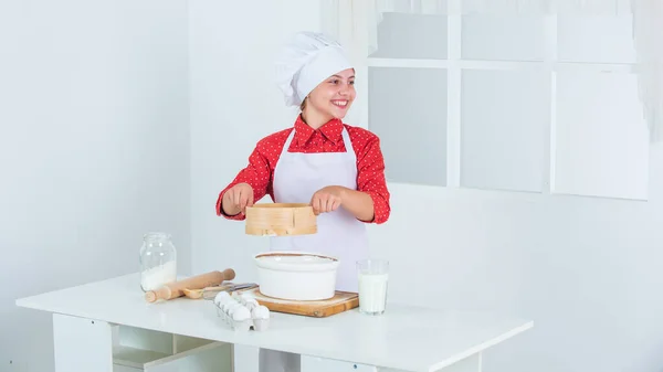 좋은 기분. 부엌에서 구운 쿠키. 전문적 이고 숙련 된 제빵사죠. 셰프 복장에 모자쓴 애. 반죽을 준비하는 십 대 소녀. 레시피로 케이크를 만드는 것입니다. 먹을 시간이야. 부엌에서 요리하는 행복 한 어린이 — 스톡 사진