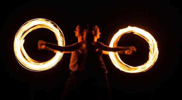 Creando impresionantes efectos de trazador. Un par de artistas realizan orbitales de fuego. Senderos de luz brillante y diseños. Desempeño. Burning Poi girando. Festival nocturno. Celebración festiva —  Fotos de Stock