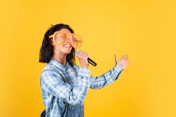Mujer bonita feliz con pelo morena usar ropa casual cantar canción en el micrófono, karaoke —  Fotos de Stock