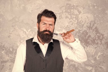 Paslanmaz Çelik Düz Ustura. Klasik traş. Sakallı adamın elinde klasik tıraş bıçağı var. Jiletle tıraş oluyorum. Berber dükkanındaki vahşi kuaför. Sakallı, zarif, olgun bir adam berber dükkanında çalışıyor.