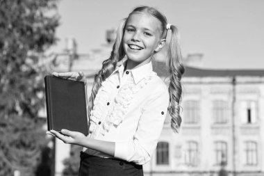 Kitap sevenler için bir ürün. Mutlu çocuk kitabı dışarıda tutuyor. Ürün sunan küçük bir kız. Ürün tanıtımı. Pazarlama ve satış. Kitapçı. Kitapçı. Okul ürünlerine dönün, alanı kopyalayın