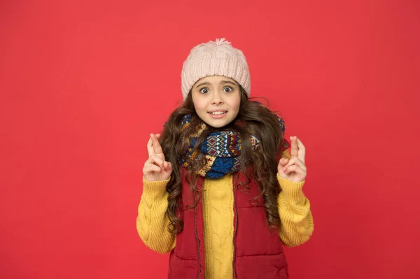Έκπληκτη όμορφη κοπέλα σε puffer γιλέκο με πλεκτό καπέλο και πουλόβερ κρατήσει σταυρωμένα δάχτυλα, κάνει μια ευχή — Φωτογραφία Αρχείου