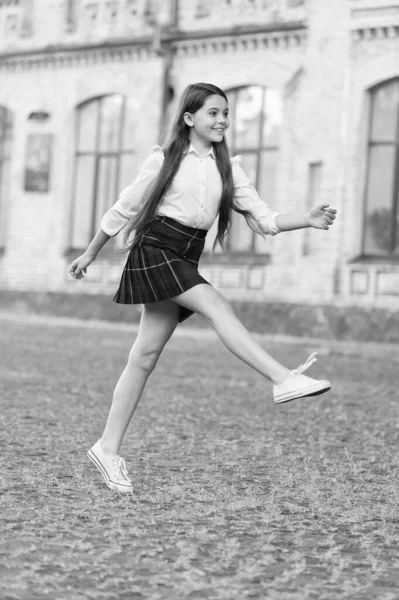 Emocionado por las vacaciones. Feliz niño celebrar las fiestas al aire libre. Chica enérgica marchando en uniforme escolar. Vacaciones escolares. Vacaciones de verano o vacaciones. Ocio y tiempo libre —  Fotos de Stock