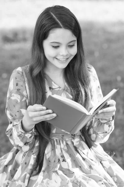 Az olvasási örömödre. Happy lány könyvet olvasott a nyári parkban. A kisgyerek szeret a szabadban olvasni. Nyári olvasmány lista. Képzelődöm. Az olvasás jó móka. — Stock Fotó