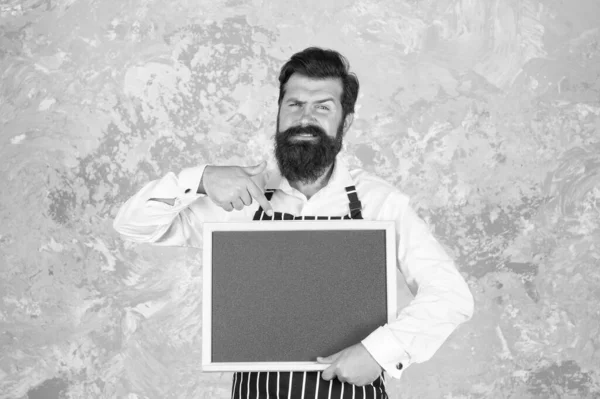 Du borde prova det här. Restaurangköksmästare. brutal skäggig man med svarta tavlan. Hipsterbarista pekar finger. Känn framgången. Café chalkboard menyn. Olycklig matlagning i köket. presentera produkten — Stockfoto