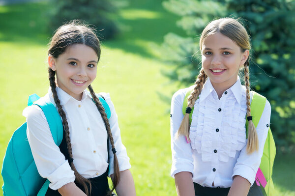 Happy kids in formal uniform enjoy sunny day outdoors after school studies, knowledge day