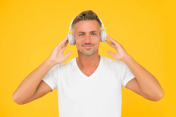 Μεσήλικας καυκάσιος φοράει ακουστικά σύγχρονης τεχνολογίας κίτρινο φόντο, ακοή — Φωτογραφία Αρχείου