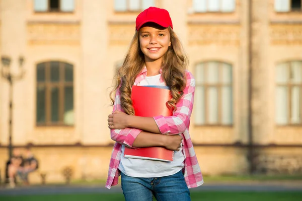 Gelukkig kind in casual mode stijl houden schoolboeken buiten, prive-onderwijs — Stockfoto