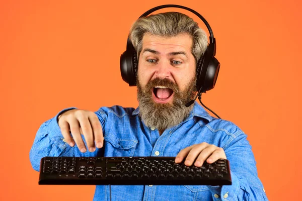 Best Service. Professional Gamer Playing Arcade computer game. chat online. Online Video Game. Cyber Championship. agile business. downloading music from internet. bearded man headphones and keyboard