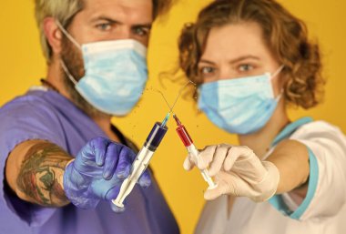 İkisini de kullan. Koronavirüse hayır de. Virüs enjeksiyonu. Doktorlar solunum maskesi takarlar. Enfeksiyon aşısı ve kan testi. Tıp profesörü çalışıyor. Tıbbi çift şırınga aşısı kullanıyor