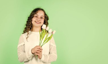 bahar çiçeği buketi. Mutlu kadınlar günü. Uluslararası Çocuk Günü. Anneler Günü konsepti. Kıvırcık saçlı neşeli küçük kız. Çocuk için lale çiçeği. Mutlu kız lale çiçeklerini tutar. Boşluğu kopyala