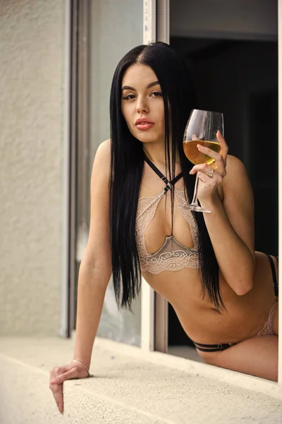 İç çamaşırlı çekici, seksi esmer kadın bardakta şarap içiyor. Şampanya ve camlı portre. Evde dinlenen bir kadın. Lüks bir hayat. Erotik iç çamaşırlı kadın. sutyen ve külot. Zengin seksi piliç — Stok fotoğraf