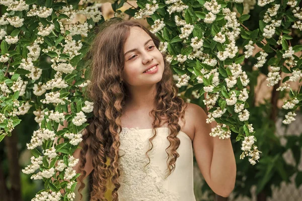 美しい少女長い巻き毛春の花の背景、満開の概念 — ストック写真