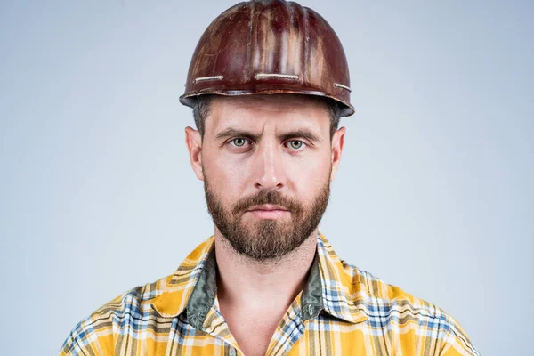 一个长相严肃的建筑师。穿工人制服的人。戴着头盔的英俊的建筑工人。成熟的男人穿格子衬衫。专业的建筑工人或机械师。建筑工程师 — 图库照片