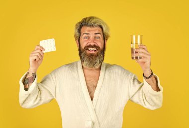 Vay canına. Evde ilaç alan bir adamın sağlık sigortası. Haplı ve bir bardak suyla yakışıklı bir adam. Ağrı kesici al. Tedavi konsepti. Sağlık hizmeti al, ilaç al. Sakallı adam hastalık izninde.