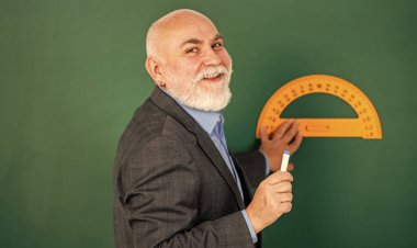 Keyfim yerinde. Sakallı özel öğretmen tahtasında cetvelle çizer. Okula dönüyorum. En sevdiği konu ve disiplin. Eğitim ve okul konsepti. Evde öğreniyorum. Usta öğretmen iletken araç kullan