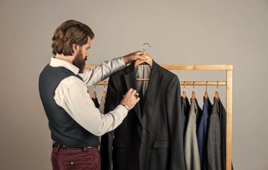 O uzman bir terzi. Bireysel insan eli ölçer. Adam içeride iş elbisesi sipariş ediyor. Terzi ölçer adamım. Çalışma alanında şık bir iş adamı. Moda tasarım stüdyosu. Erkek moda tasarımcısı