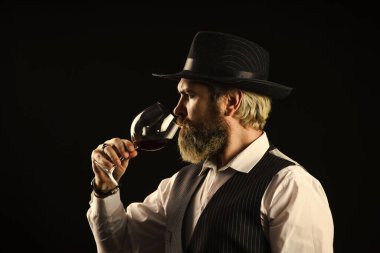 Seçkin içki. Rengini ve şarap tortularını kontrol ediyorum. Şarap tatma. Erkek yetenekli şarap garsonu alkollü içki olduğunu tahmin ediyor. Uzun saplı şarap kadehlerinde kırmızı şarap. Sakallı adam restoranın tadını keşfeder.