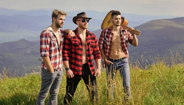 Enjoying happy moments. hiking adventure. cowboy men. men with guitar in checkered shirt. western camping. campfire songs. group of people spend time together. happy men with guitar. friendship