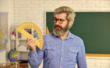 Matematik dersi. Eğitim konsepti. Yetenekli pedagog. Özel ders. Okula dönelim. Matematik çalış. Erkek öğretmen okul projelerine rehberlik ediyor. Modern bilim okulu. Gözlüklü olgun sakallı öğretmen.