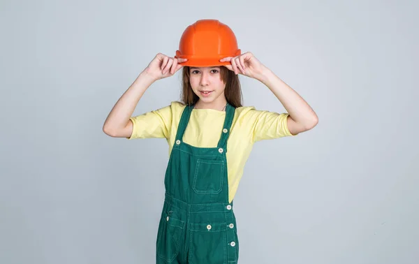 A gyerek építkezik. Mérnök tinédzser építőmunkás. nemzetközi munkások napja. A villanyszerelő a karrierje. A bukósisakos lány építész. építés és felújítás. Az épület az élete. — Stock Fotó