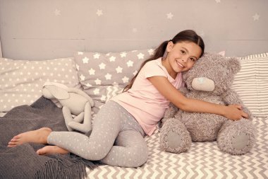 Sarılmak için ideal. Mutlu çocuk oyuncak ayıyı yatakta tut. Küçük kız yumuşak oyuncaklarla oynuyor. Oyuncak dükkanı ya da mağaza. Çocuk oyuncağı. Oyun zamanı. Çocukluk Oyunları