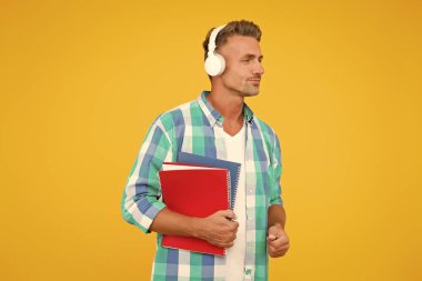 Dil çalış. Ücretsiz yemek. Ses kursları. İngilizce öğreniyorum. Modern teknoloji. Ses kitabı konsepti. Dünya çapında bilgi erişimi. Ses kütüphanesi. Yakışıklı öğrenci kulaklık takıyor.