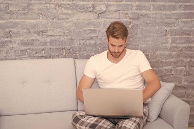 Sosyal uzaklık. Adam bilgisayarda çalışıyor. Çevrimiçi kurslar. Evde eğitim. İnternetten alışveriş. Adam bilgisayar gevşetici kanepe kullanıyor. Çevrimiçi iletişim kavramı. Evden çalışıyorum. Kendini soyutlama. Evde kal.