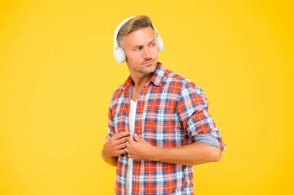 Hombre guapo botón camisa casual escuchar música en los auriculares modernos fondo amarillo, la vida moderna — Foto de Stock