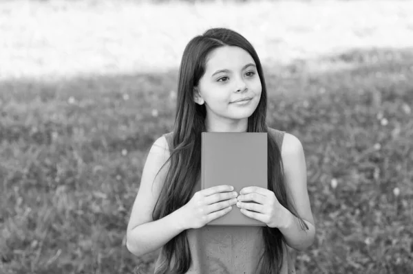 Boek een dag houdt verveling weg. Klein meisje houdt het boek buiten. Kleine lezer op zomerdag. Bibliotheekboek. Fantasie en fictie. Literatuur en poëzie. Leesgewoonte. Verdwaal in een goed boek — Stockfoto