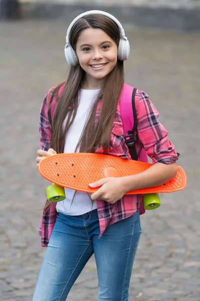 Cabalga todos los días. Niño feliz mantenga penny board al aire libre. Junta para el transporte. Actividad recreativa. Deporte de acción. Viaje y aventura. Patinaje callejero. Impulsado por monopatín — Foto de Stock