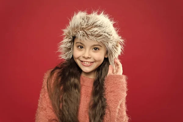 Concepto de moda de invierno. Sombrero cálido para clima frío. Accesorio perfecto. Chica usar sombrero con orejeras fondo blanco. Accesorio peludo suave. Cuidado de las prendas de piel. Niño pelo largo sombrero suave disfrutar de la suavidad — Foto de Stock