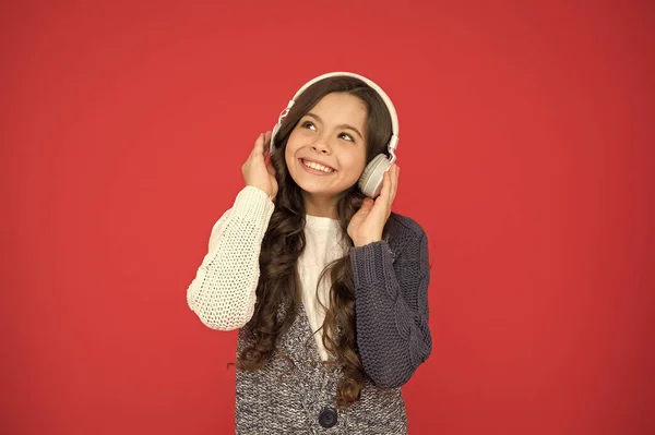 Niña linda niña usar auriculares escuchar música. El chico escucha música de fondo rojo. Música recomendada basada en el interés inicial. Las mejores aplicaciones de música para tu dispositivo. Disfruta del sonido. Canta conmigo. —  Fotos de Stock