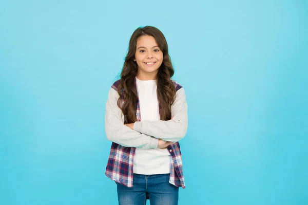 Beleza confiante. Pequena beleza. expressar emoções positivas. feliz parede turquesa menina pequena. aluna alegre tem cabelo encaracolado longo. criança usar jaqueta casual na moda. criança primavera e outono moda — Fotografia de Stock