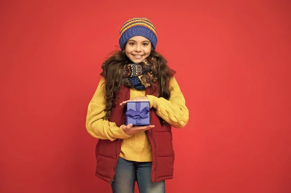 Menina de inverno com caixa de presente de ano novo. Boas férias de inverno. pequena menina de malha chapéu e cachecol. Pronto para o Natal. Ela vai à festa de Natal. vendas sazonais de compras. felicidade infantil — Fotografia de Stock