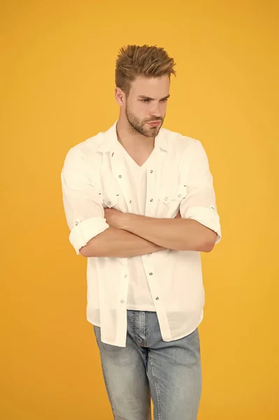 Concepto de moda y gente. Sexy y guapo. Joven y apuesto hombre con camisa vaquera. tipo vistiendo jeans y camiseta. un hombre con camisa blanca. Hombre musculoso en pantalones vaqueros de fondo amarillo. Joven y libre — Foto de Stock