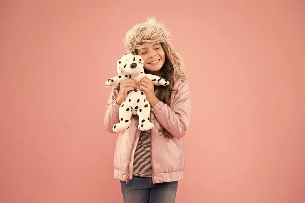 Positieve emoties. Gelukkig klein lachend kind spelen met zachte hond op roze achtergrond. Gelukkig klein kind speeltje vasthouden. Vriendelijkheid concept. Heerlijk vrolijke kindvriendelijke hond. Liefdadigheids- en schenkingsconcept — Stockfoto