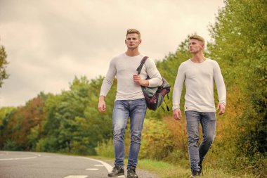 Uzak durun. Otostop yaparak. Yolculuk. Yolculuk tutkusu konsepti. Arkadaşlarla yürüyüş yapmak harika. Kendilerini bulmaya gittiler. Seyahat ve otostop. Yol boyunca yürüyen ikizler. Boş yolda otostop çekerek..